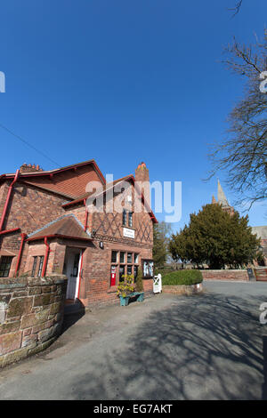 Village de Aldford, Angleterre. Vue pittoresque du village store avec St Jean Baptiste l'église de l'arrière-plan. Banque D'Images