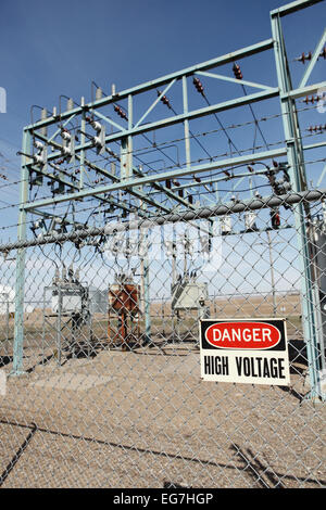 Un panneau d'avertissement de haute tension sur la clôture autour d'une sous-station électrique. Banque D'Images