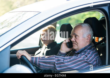 Ancien pilote dans la voiture à l'aide d'smartphone, passagère dans la voiture Banque D'Images