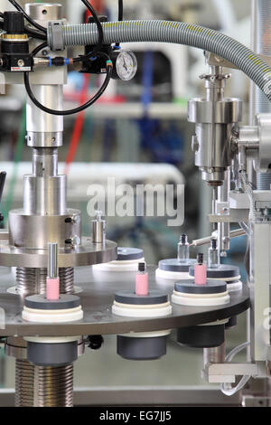 Le remplissage des flacons d'une machine dans une usine de produits cosmétiques. Banque D'Images