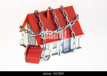 Image symbolique, la sécurité à domicile, la prévention des cambriolages, et chaîne en acier autour d'un modèle de maison, Banque D'Images