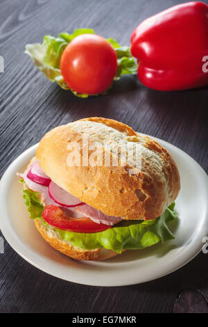 Panneaux sandwich au jambon avec des tomates sur un pain aux graines mixtes Banque D'Images