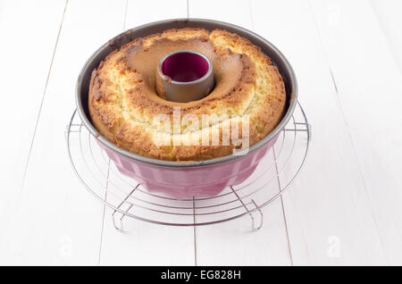 Gugelhupf frais cuit dans un moule à pâtisserie rose sur blanc bois Banque D'Images