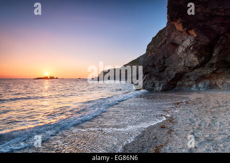 Coucher du soleil à Polpeor Cove, une petite plage au pied du cap Lizard en Cornouailles Banque D'Images