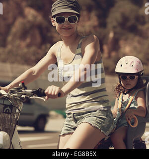 Femme et enfant équitation dans des lunettes de soleil. Vintage closeup portrait Banque D'Images