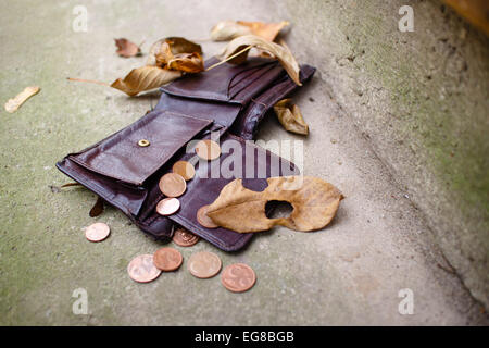 Ancien porte-monnaie avec les pièces en euros sur un sol en béton. Banque D'Images