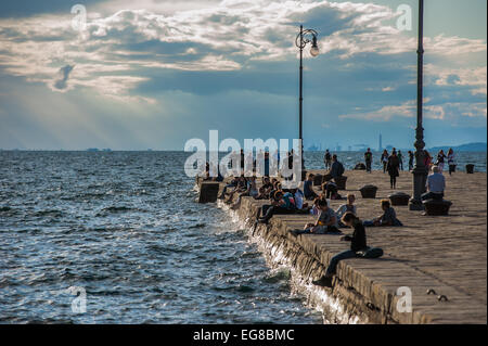 Trieste, Italie - touristes et habitants profiter de la lumière de l'après-midi sur le Molo Audace quai en face de la place centrale. Banque D'Images