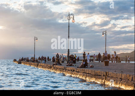 Trieste, Italie - touristes et habitants profiter du coucher du soleil sur le Molo Audace pier Banque D'Images