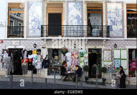 Les touristes assis à l'extérieur d'un café dans le tourisme populaire Alfama de Lisbonne au Portugal Banque D'Images