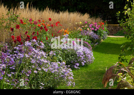 Chemin d'herbe au début de l'automne avec les pensionnaires en jardin anglais, Oxfordshire, Angleterre Banque D'Images