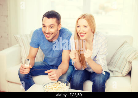 Smiling couple avec popcorn sports team cheering Banque D'Images