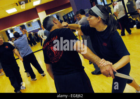 Photos de Krav Maga : un mode d'auto défense pratiqué et rendue populaire par l'armée israélienne basée sur un combo de Judo et Ju-jitsu , Karaté Kung Fu - dark haired girl rôles swaps avec formateur Mike démontrant un certain nombre d'attaque/situations de légitime défense - plus des professionnels et en particulier les femmes prennent ces sortes de classes peut-être en réponse à une augmentation de la violence physique sur les rues de Londres lieu de tournage 'Fitness First' London W1 20 mai 2007 publié le 11 juin 2007 commission le london lite formateur photo Mike Kapsalis Mike et étudiants www.kravmagalon parution modèle Banque D'Images