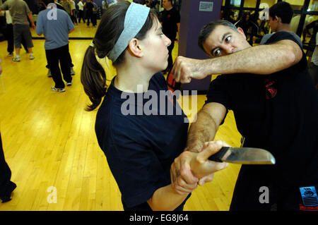 Photos de Krav Maga : un mode d'auto défense pratiqué et rendue populaire par l'armée israélienne basée sur un combo de Judo et Ju-jitsu , Karaté Kung Fu - dark haired girl rôles swaps avec formateur Mike démontrant un certain nombre d'attaque/situations de légitime défense - plus des professionnels et en particulier les femmes prennent ces sortes de classes peut-être en réponse à une augmentation de la violence physique sur les rues de Londres lieu de tournage 'Fitness First' London W1 20 mai 2007 publié le 11 juin 2007 commission le london lite formateur photo Mike Kapsalis Mike et étudiants www.kravmagalon parution modèle Banque D'Images