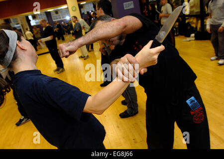 Photos de Krav Maga : un mode d'auto défense pratiqué et rendue populaire par l'armée israélienne basée sur un combo de Judo et Ju-jitsu , Karaté Kung Fu - dark haired girl rôles swaps avec formateur Mike démontrant un certain nombre d'attaque/situations de légitime défense - plus des professionnels et en particulier les femmes prennent ces sortes de classes peut-être en réponse à une augmentation de la violence physique sur les rues de Londres lieu de tournage 'Fitness First' London W1 20 mai 2007 publié le 11 juin 2007 commission le london lite formateur photo Mike Kapsalis Mike et étudiants www.kravmagalon parution modèle Banque D'Images