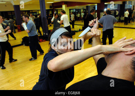 Photos de Krav Maga : un mode d'auto défense pratiqué et rendue populaire par l'armée israélienne basée sur un combo de Judo et Ju-jitsu , Karaté Kung Fu - dark haired girl rôles swaps avec formateur Mike démontrant un certain nombre d'attaque/situations de légitime défense - plus des professionnels et en particulier les femmes prennent ces sortes de classes peut-être en réponse à une augmentation de la violence physique sur les rues de Londres lieu de tournage 'Fitness First' London W1 20 mai 2007 publié le 11 juin 2007 commission le london lite formateur photo Mike Kapsalis Mike et étudiants www.kravmagalon parution modèle Banque D'Images