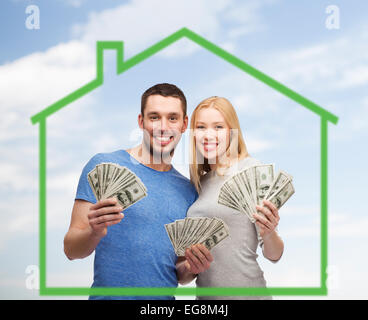 Smiling couple holding argent sur green house Banque D'Images