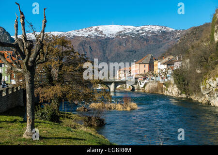 Tarascon sur Ariege Ariege et rivière avec pont, arbres taillés et les bâtiments avec les montagnes enneigées Banque D'Images