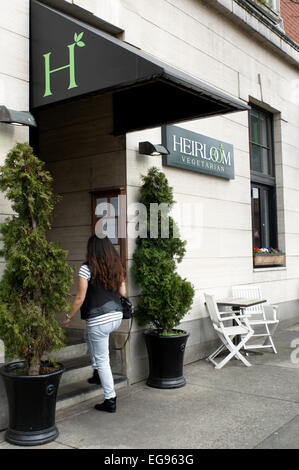 Jeune femme entrant Heirloom restaurant végétarien de Vancouver, BC, Canada Banque D'Images
