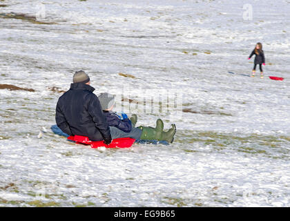 Man and boy sur l'ensemble de la Luge Luge descente sur snowy hillside Caldbeck fells, Lake District, Cumbria, Angleterre, Royaume-Uni Banque D'Images