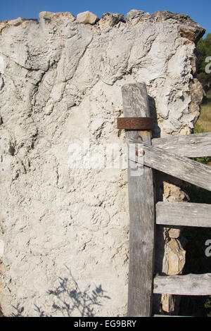 Porte en bois naturel blanchi soleil attaché à un mur en pierre sèche Banque D'Images