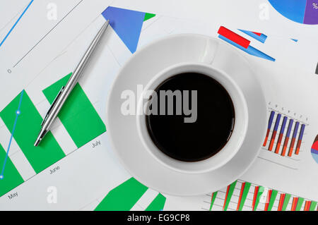 Capture d'un grand angle d'une tasse de café sur un bureau plein de tableaux dans le bureau Banque D'Images