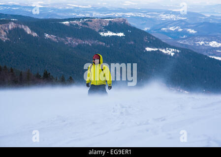 Homme marchant dans les montagnes en hiver Banque D'Images