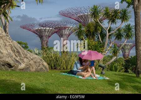 Mère et fille assise sous un parasol dans les jardins près de la baie, Singapour Banque D'Images