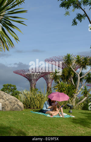 Mère et fille assise sous un parasol dans les jardins près de la baie, Singapour Banque D'Images