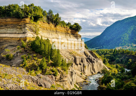 Le Chili, le Parc National Conguillio, Araucania, falaise boisée sur la rivière Banque D'Images