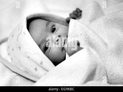 Jeune bébé couché à mignon sous une couverture dans son lit Banque D'Images