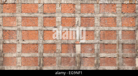 La texture de fond de l'ancien mur de la maison faite de briques rouges et de béton gris Banque D'Images