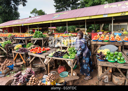 Une femme vendant des légumes sur un marché de rue, Kampala, Ouganda. Banque D'Images