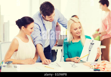 Smiling fashion designers working in office