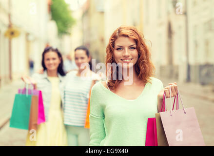 Smiling teenage girls with shopping bags on street Banque D'Images