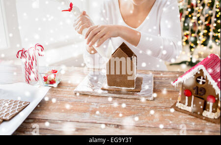 Close up of woman making gingerbread houses Banque D'Images