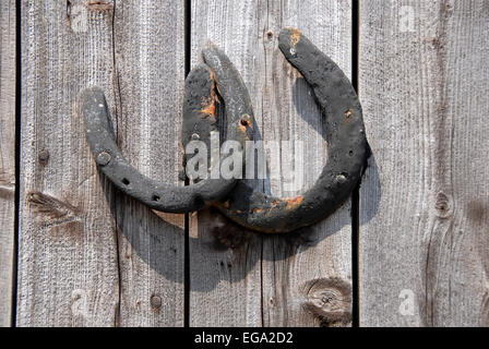 Deux vieux cheval chaussures clouée sur la porte en bois Banque D'Images