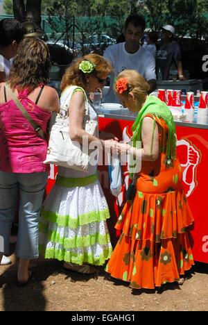 Deux femmes en robes de flamenco espagnol debout à un snack-bar à la Romeria San Bernabé, Marbella, Costa del Sol, Espagne. Banque D'Images