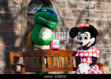 Blackpool, Lancashire, Royaume-Uni 21 février, 2015. Météo britannique. Rock FM Paiement pour les enfants est l'organisme officiel de Rock FM et fournit une aide aux personnes handicapées et les enfants défavorisés dans le Lancashire. La charité de collectionneurs, Minnie et NinjaTurtle dans le parc de St Chad's Church l'église anglicane à Poulton-le-Fylde, réputé pour sa floraison du printemps affichage des bulbes de crocus. Fleurs de crocus sont habituellement parmi les premiers à apparaître au printemps. Credit : Cernan Elias/Alamy Live News Banque D'Images