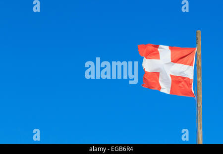 Le lire et le drapeau blanc de hauite Savoie (Département 74) en France à voler d'un mât contre un ciel bleu clair. Banque D'Images