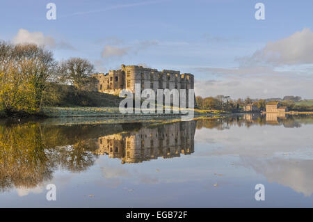 Château de Carew début matin givre reflète dans l'étang de l'usine (Welsh historic site) Banque D'Images