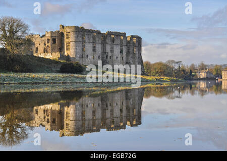 Château de Carew début matin givre reflète dans l'étang de l'usine (Welsh historic site) Banque D'Images