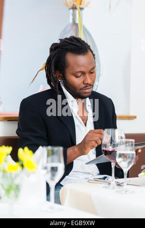 L'homme d'affaires, d'afro-américains, avec tablette en restaurant un déjeuner au restaurant Banque D'Images
