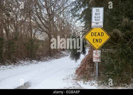 Route boisée enneigée avec dead end devant à l'entrée. Banque D'Images