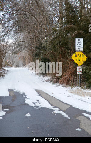 Route boisée enneigée avec dead end devant à l'entrée. Banque D'Images