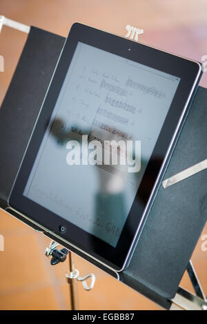 Réflexion sur un ipad de violoniste avec son violon jouant pendant un mariage alors que la lecture de partitions digitales Banque D'Images