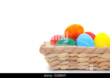 Oeufs de Pâques en panier sur fond blanc Banque D'Images