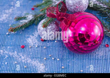 Ornement rose boule de Noël avec un sapin sur nappe blanche Banque D'Images