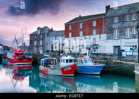 Bateaux de pêche dans le port de Padstow à Cornwall sous un ciel dramatique au lever du soleil. Banque D'Images