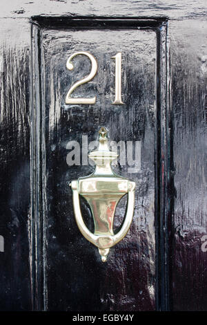 Angleterre, Sandwich. Porte avant, numéro de rue 21 avec porte de défonce en dessous. Porte en bois noir, avec numéro en métal Banque D'Images