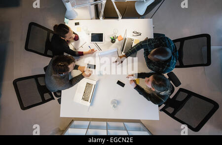 Vue supérieure de l'équipe diversifiée de l'analyse des données alors qu'il était assis au bureau. Les gens d'affaires multiracial dans une réunion de travail. Banque D'Images